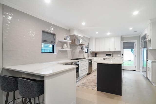 3710 Binkley Ave, University Park, TX 75205 - kitchen featuring a peninsula, backsplash, white cabinetry, beverage cooler, and crown molding