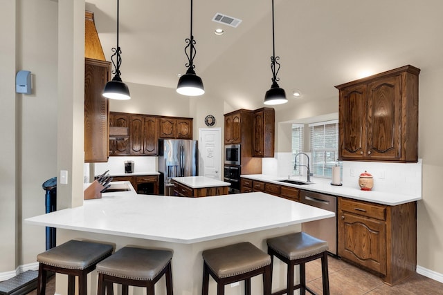 5210 Medallion Ct, Midlothian, TX 76065 - kitchen featuring appliances with stainless steel finishes, a sink, a kitchen breakfast bar, a peninsula, and tasteful backsplash
