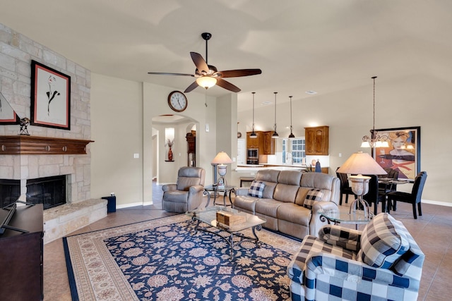 5210 Medallion Ct, Midlothian, TX 76065 - living room featuring a ceiling fan, tile patterned floors, arched walkways, a chandelier, and a stone fireplace