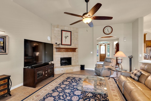 5210 Medallion Ct, Midlothian, TX 76065 - tiled living area with ceiling fan, arched walkways, a fireplace, and baseboards