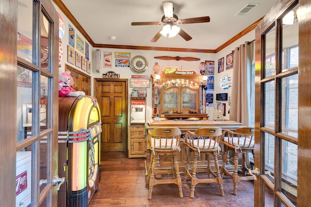 5210 Medallion Ct, Midlothian, TX 76065 - dining space featuring crown molding, healthy amount of natural light, a ceiling fan, bar area, and hardwood / wood-style flooring