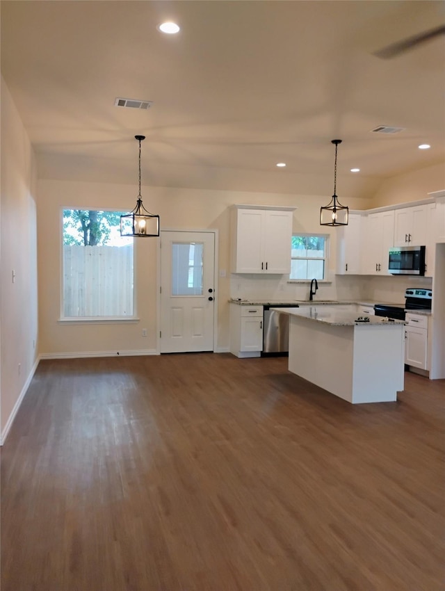 901 SW 10th St, Mineral Wells, TX 76067 - kitchen featuring stainless steel appliances, dark wood-style floors, white cabinetry, baseboards, and a kitchen island
