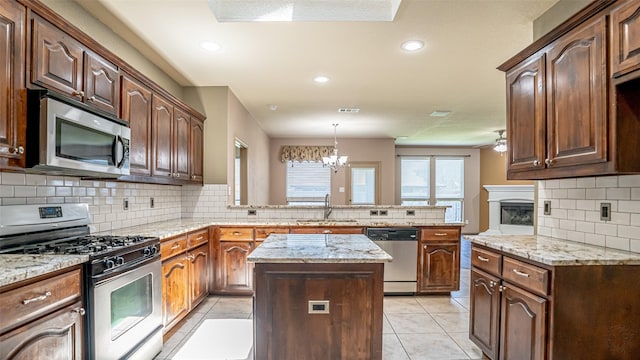 10252 Los Barros Trl, Fort Worth, TX 76177 - kitchen featuring appliances with stainless steel finishes, a peninsula, a sink, decorative backsplash, and recessed lighting