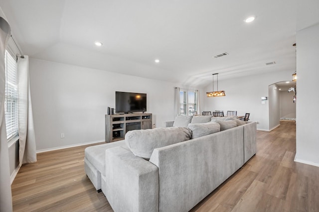 900 Sapphire Dr, Princeton, TX 75407 - living room with arched walkways, light wood-type flooring, baseboards, recessed lighting, and lofted ceiling