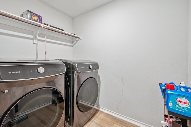 900 Sapphire Dr, Princeton, TX 75407 - laundry room featuring washing machine and clothes dryer, baseboards, and wood finished floors