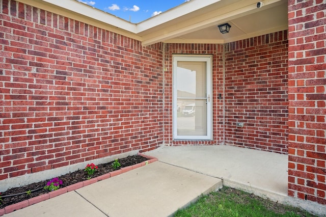 900 Sapphire Dr, Princeton, TX 75407 - property entrance featuring a patio, brick siding, and a surveillance system