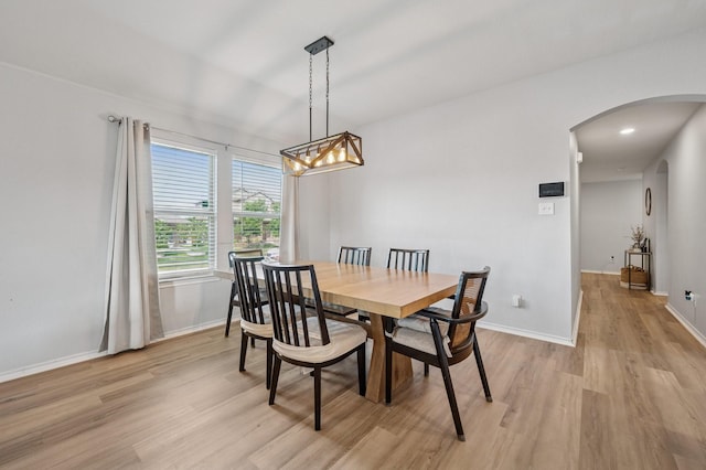 900 Sapphire Dr, Princeton, TX 75407 - dining room featuring arched walkways, light wood-style flooring, and baseboards