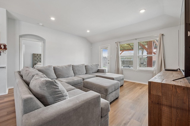 900 Sapphire Dr, Princeton, TX 75407 - living room featuring arched walkways, light wood-type flooring, recessed lighting, baseboards, and vaulted ceiling