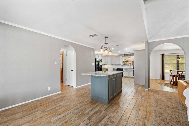 2801 Good Shepherd Dr, Brownwood, TX 76801 - kitchen with black fridge with ice dispenser, arched walkways, ornamental molding, light wood-style flooring, and gray cabinets