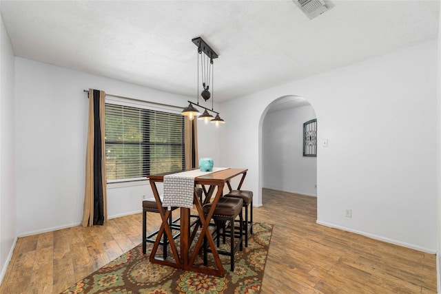 2801 Good Shepherd Dr, Brownwood, TX 76801 - dining area featuring arched walkways, wood-type flooring, and baseboards