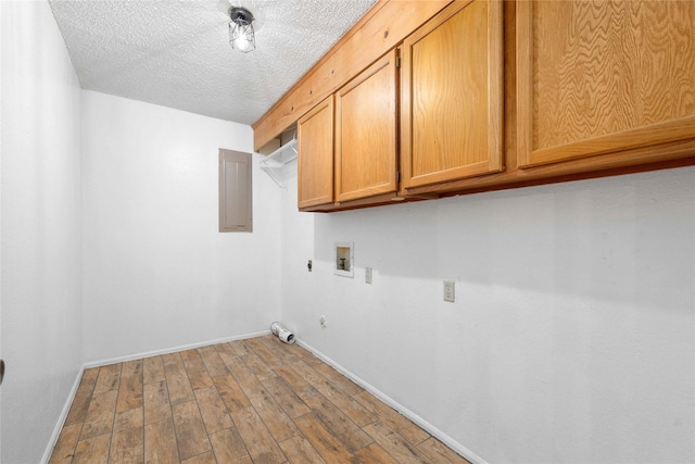2801 Good Shepherd Dr, Brownwood, TX 76801 - laundry room with cabinet space, hookup for a washing machine, baseboards, hookup for an electric dryer, and a textured ceiling