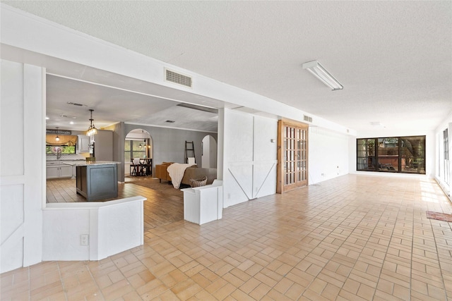 2801 Good Shepherd Dr, Brownwood, TX 76801 - living area featuring arched walkways, brick patterned flooring, and a textured ceiling