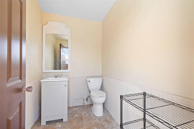 2801 Good Shepherd Dr, Brownwood, TX 76801 - half bathroom featuring toilet, wainscoting, and vanity