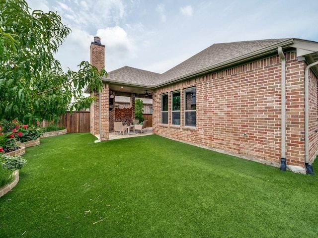 7621 Newtown, The Colony, TX 75056 - back of house with a fenced backyard, a ceiling fan, a chimney, and brick siding