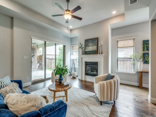 7621 Newtown, The Colony, TX 75056 - living room featuring plenty of natural light, a ceiling fan, wood-type flooring, a fireplace, and recessed lighting