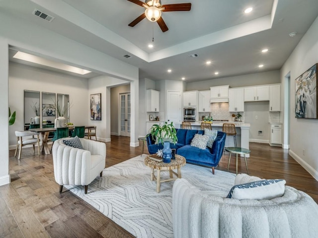 7621 Newtown, The Colony, TX 75056 - living room featuring ceiling fan, dark wood-style flooring, a raised ceiling, recessed lighting, and a desk