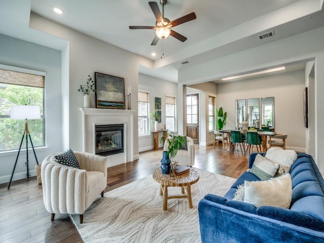 7621 Newtown, The Colony, TX 75056 - living area featuring healthy amount of natural light, recessed lighting, wood finished floors, a ceiling fan, and a glass covered fireplace