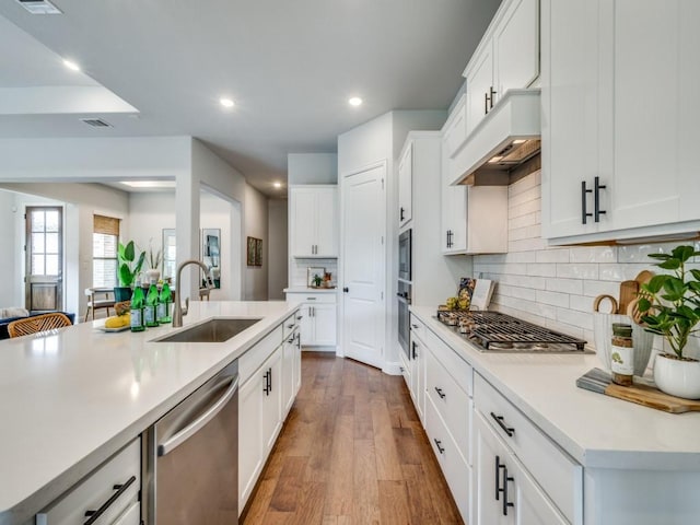 7621 Newtown, The Colony, TX 75056 - kitchen with stainless steel appliances, custom range hood, light countertops, recessed lighting, and decorative backsplash
