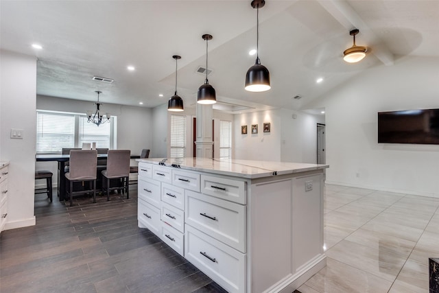 1321 Glyndon Dr, Plano, TX 75023 - kitchen with light stone countertops, a center island, white cabinets, recessed lighting, and pendant lighting