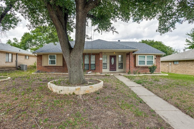 1321 Glyndon Dr, Plano, TX 75023 - view of front of house with central AC unit, brick siding, and roof with shingles