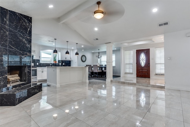 1321 Glyndon Dr, Plano, TX 75023 - foyer featuring decorative columns, a ceiling fan, a premium fireplace, light marble finish flooring, and baseboards