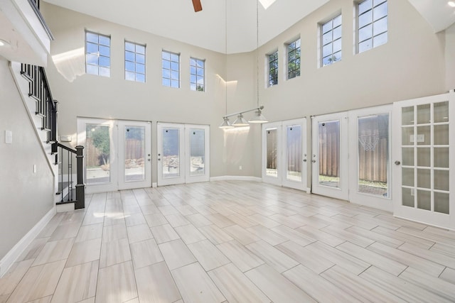4616 Heatherbrook Ln, Grand Prairie, TX 75052 - unfurnished living room with french doors, a towering ceiling, a ceiling fan, stairs, and baseboards