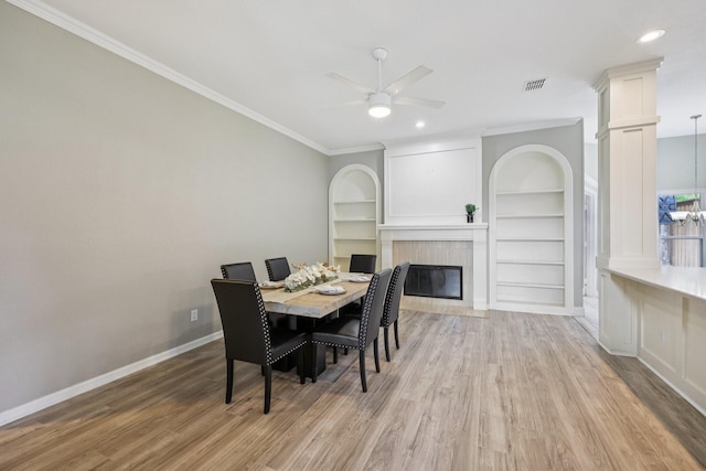 4616 Heatherbrook Ln, Grand Prairie, TX 75052 - dining room with a fireplace with flush hearth, baseboards, light wood-style floors, a ceiling fan, and ornamental molding