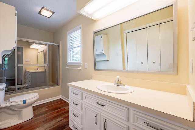 522 E Kempner St, Mabank, TX 75147 - bathroom with toilet, vanity, wood finished floors, bath / shower combo with glass door, and baseboards