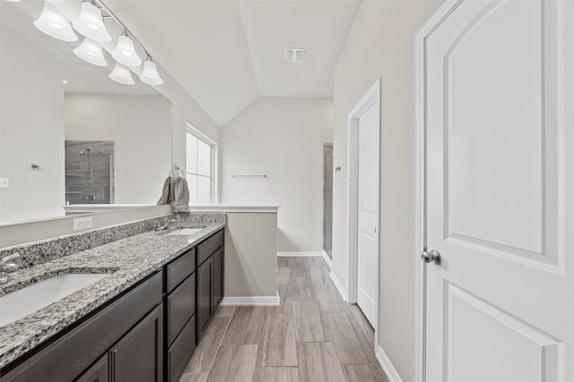 3009 Gilchrist Dr, Lorena, TX 76655 - full bath featuring a stall shower, double vanity, vaulted ceiling, baseboards, and wood finished floors