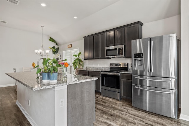 3009 Gilchrist Dr, Lorena, TX 76655 - kitchen with appliances with stainless steel finishes, lofted ceiling, dark wood-type flooring, a chandelier, and a center island with sink