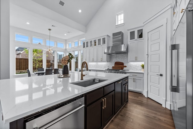 1733 Cousins Trl, Frisco, TX 75034 - kitchen featuring appliances with stainless steel finishes, wall chimney range hood, a sink, high vaulted ceiling, and an island with sink