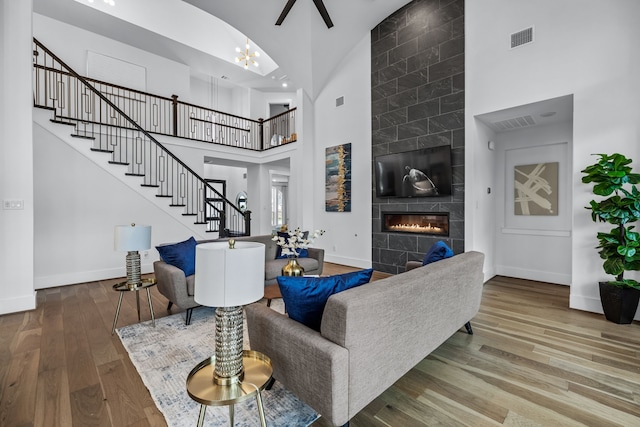 1733 Cousins Trl, Frisco, TX 75034 - living room with a high ceiling, stairs, baseboards, wood finished floors, and a tile fireplace