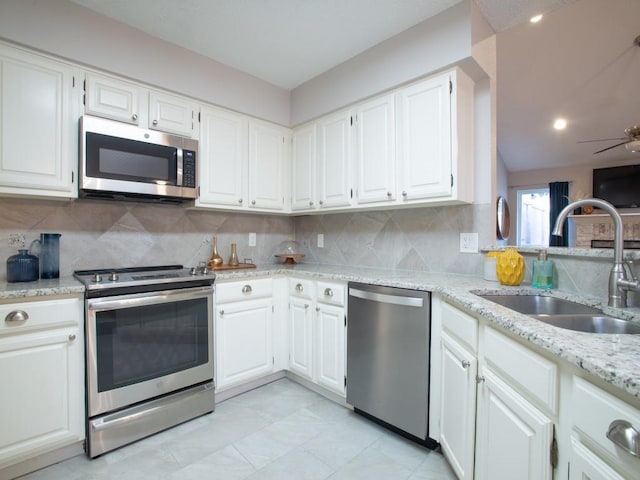 2800 Country Villa Cir, Carrollton, TX 75006 - kitchen featuring appliances with stainless steel finishes, a sink, a ceiling fan, backsplash, and light stone countertops