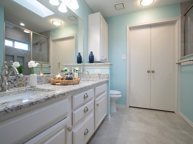 2800 Country Villa Cir, Carrollton, TX 75006 - bathroom featuring a skylight, double vanity, toilet, tiled shower, and baseboards