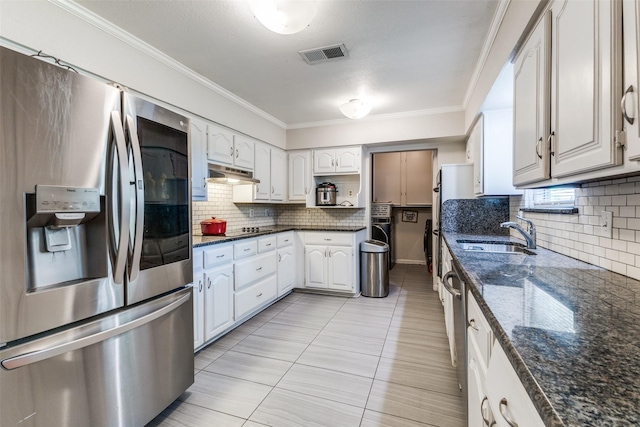 2029 Aloha Dr, Mesquite, TX 75150 - kitchen with stainless steel appliances, a sink, under cabinet range hood, tasteful backsplash, and crown molding