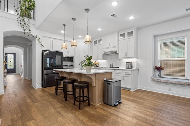 1431 Cypress Thorn Dr, Arlington, TX 76005 - kitchen with stainless steel appliances, a kitchen breakfast bar, arched walkways, baseboards, and white cabinetry