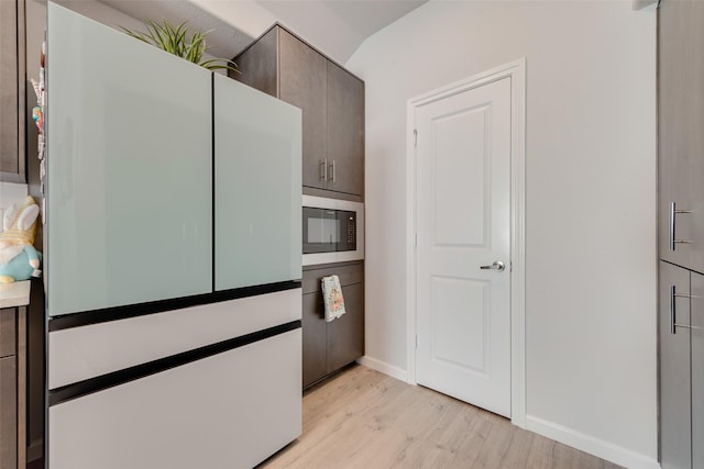 3615 Big Nemaha Dr, Crandall, TX 75114 - kitchen with freestanding refrigerator, light wood finished floors, built in microwave, baseboards, and dark brown cabinets