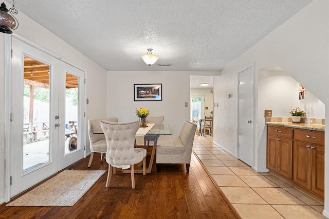 818 Placid Dr, Mesquite, TX 75150 - dining room with a textured ceiling, healthy amount of natural light, light wood-type flooring, and french doors