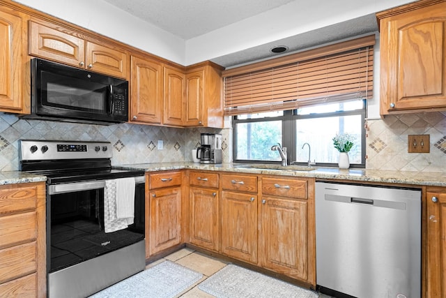 818 Placid Dr, Mesquite, TX 75150 - kitchen featuring appliances with stainless steel finishes, a sink, decorative backsplash, and light stone countertops