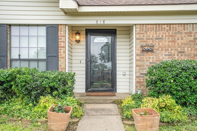 818 Placid Dr, Mesquite, TX 75150 - view of exterior entry with brick siding and a shingled roof