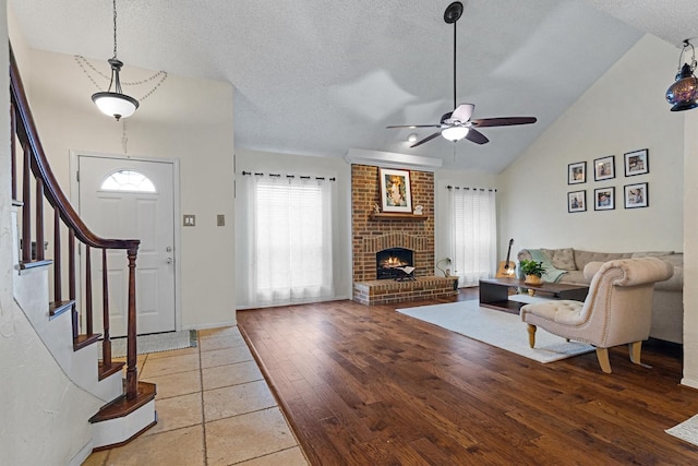 818 Placid Dr, Mesquite, TX 75150 - living area with a textured ceiling, ceiling fan, vaulted ceiling, stairway, and a fireplace