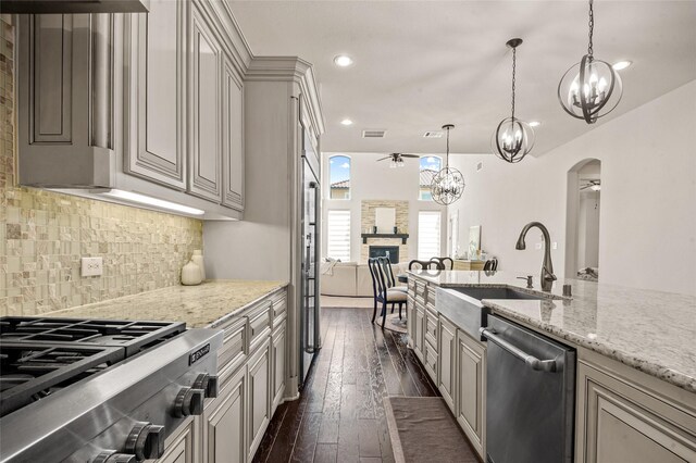 2504 Las Palmas Ln, Plano, TX 75075 - kitchen featuring stainless steel appliances, a sink, arched walkways, ceiling fan, and dark wood finished floors