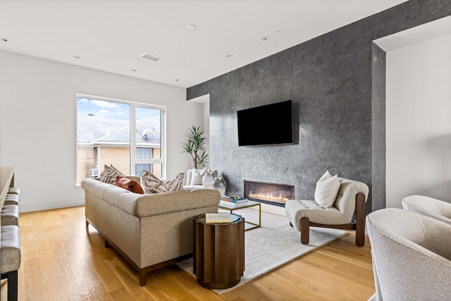 3909 Hawthorne Ave Unit 101, Dallas, TX 75219 - living room with an accent wall, a fireplace, and light wood-type flooring