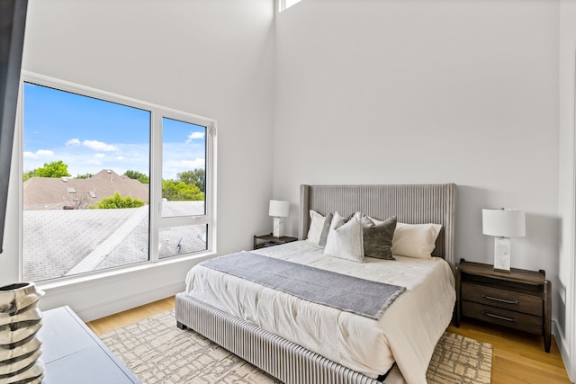 3909 Hawthorne Ave Unit 101, Dallas, TX 75219 - bedroom with multiple windows, light wood-type flooring, and a towering ceiling