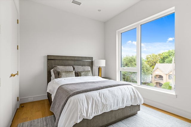 3909 Hawthorne Ave Unit 101, Dallas, TX 75219 - bedroom with multiple windows, wood finished floors, and baseboards