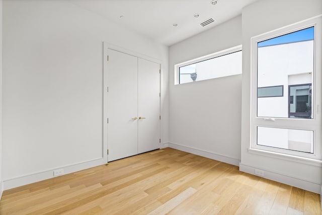 3909 Hawthorne Ave Unit 101, Dallas, TX 75219 - unfurnished bedroom featuring light wood-type flooring and baseboards