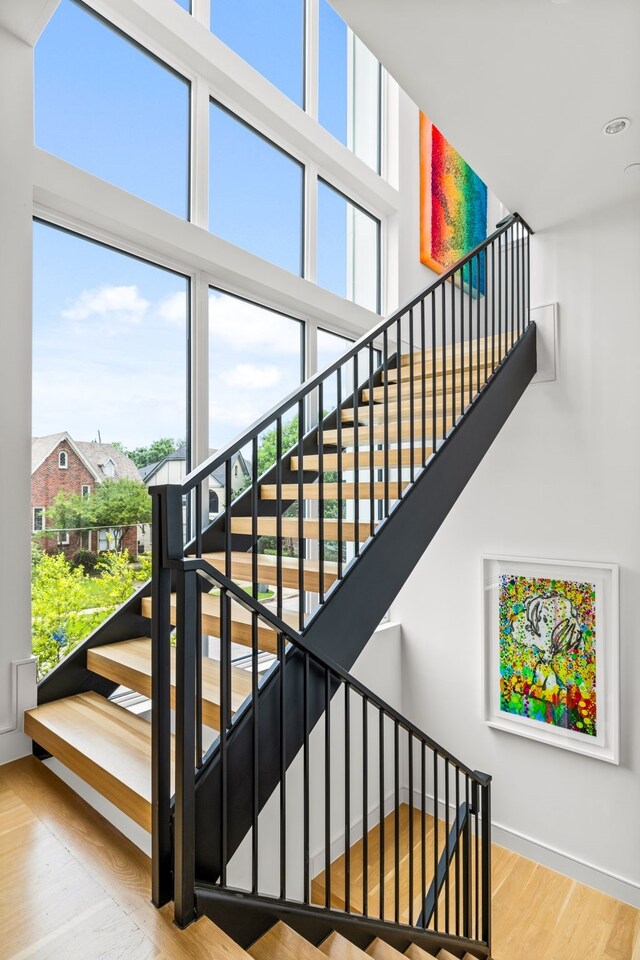 3909 Hawthorne Ave Unit 101, Dallas, TX 75219 - stairs with a high ceiling, wood finished floors, and baseboards