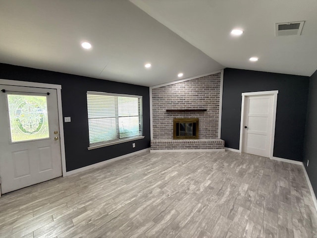 137 W 6th St, Krum, TX 76249 - unfurnished living room with a brick fireplace, healthy amount of natural light, light wood-style flooring, lofted ceiling, and recessed lighting