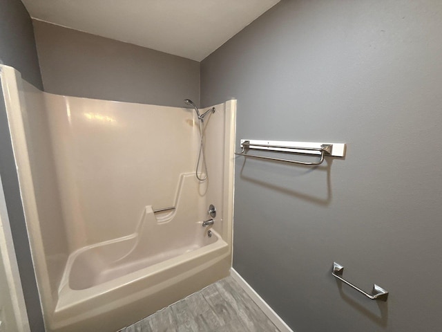 137 W 6th St, Krum, TX 76249 - bathroom with washtub / shower combination, wood finished floors, and baseboards