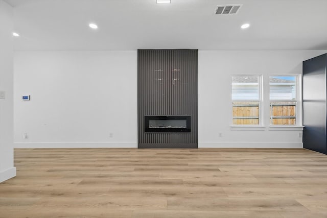 3923 Le May Ave, Dallas, TX 75216 - unfurnished living room featuring light wood-style floors, recessed lighting, baseboards, and a glass covered fireplace